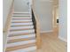 Elegant staircase with white risers, wood treads, and a modern black railing at 5611 Meadowstone Walk, Kennesaw, GA 30152