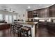 Modern kitchen island featuring granite countertops, dark wood cabinets, and three bar stools at 1222 Lavista Ne Cir, Atlanta, GA 30324