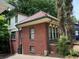 Brick home showcasing a red tile roof, green trim, and a bright and cheery two-story addition at 1225 Cameron Ne Ct, Atlanta, GA 30306