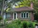 Brick home featuring arched windows, a red tile roof, and an elegant entrance, set in a leafy neighborhood at 1225 Cameron Ne Ct, Atlanta, GA 30306