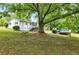 View of the backyard featuring a swing hanging from a large tree, the house, and an in-ground pool at 1430 Mineral Springs Rd, Hoschton, GA 30548