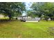 Vast green backyard with the house and a wooden deck in the distance at 1430 Mineral Springs Rd, Hoschton, GA 30548
