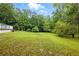 View of backyard with luscious green grass and beautiful green trees that surround the space at 1430 Mineral Springs Rd, Hoschton, GA 30548