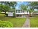 Spacious backyard featuring a white home with a wooden deck, a sunroom, and a stone pathway at 1430 Mineral Springs Rd, Hoschton, GA 30548