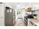 Galley kitchen featuring stainless appliances, white cabinets, granite counters, and a view of the backyard at 1430 Mineral Springs Rd, Hoschton, GA 30548