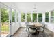 Bright sunroom with lots of natural light, dining set, and access to an outdoor deck at 1430 Mineral Springs Rd, Hoschton, GA 30548