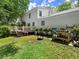 Backyard with a white two-story house, woodpile, green grass, and a charming outdoor space at 2458 Zachary Woods Dr, Marietta, GA 30064