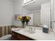 Bathroom with white countertop, flower arrangement, mirror, and decorative wallpaper accents at 2458 Zachary Woods Dr, Marietta, GA 30064