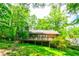 Charming wood home boasts a spacious deck surrounded by lush greenery at 2738 Westminister Nw Ln, Conyers, GA 30012