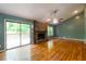 Open living room with hardwood floors, stone fireplace, sliding glass door to deck, and natural light at 2738 Westminister Nw Ln, Conyers, GA 30012