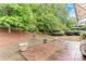 Private backyard with large trees and stamped concrete patio with garden pots at 4460 Delano Dr, Cumming, GA 30040
