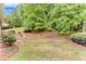 The level backyard features mature landscaping, a seating area, and a patio at 4460 Delano Dr, Cumming, GA 30040