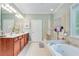 Bright bathroom with double vanity, soaking tub, and glass enclosed shower at 4460 Delano Dr, Cumming, GA 30040