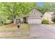 Inviting home exterior featuring a two-car garage, manicured lawn, and classic design elements at 4460 Delano Dr, Cumming, GA 30040