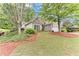 Charming home exterior with stone accents, lush landscaping, and a well-maintained lawn at 4460 Delano Dr, Cumming, GA 30040