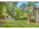 Expansive backyard with lush green lawn, mature trees, and a charming playground for outdoor enjoyment at 1343 Peachtree Battle Nw Ave, Atlanta, GA 30327