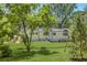 Beautiful backyard view showcasing a well-maintained lawn, mature trees, and rear exterior of the home at 1343 Peachtree Battle Nw Ave, Atlanta, GA 30327