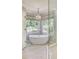 Relaxing bathroom features a soaking tub under an elegant chandelier with natural light from the garden view windows at 1343 Peachtree Battle Nw Ave, Atlanta, GA 30327