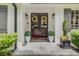 Inviting front entrance with dark wood double doors, adorned with yellow wreaths, potted plants and a stone porch at 1343 Peachtree Battle Nw Ave, Atlanta, GA 30327