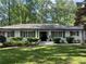 Charming single-story home with classic white brick, black trim and shutters, complemented by a lush green lawn and mature trees at 1343 Peachtree Battle Nw Ave, Atlanta, GA 30327