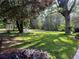 Spacious front yard with mature trees and lush green grass, offering a serene and picturesque view of the surrounding nature at 1343 Peachtree Battle Nw Ave, Atlanta, GA 30327