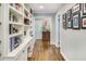 Hallway featuring hardwood floors, custom built-in bookshelves, and tasteful decorations leading to the rest of the home at 1343 Peachtree Battle Nw Ave, Atlanta, GA 30327