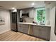 Updated kitchen with grey cabinets, stainless steel appliances, and a view to the backyard through the bright window above the sink at 1343 Peachtree Battle Nw Ave, Atlanta, GA 30327
