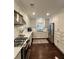 Modern kitchen features white cabinets, stainless steel appliances, marble countertops and backsplash, with hardwood flooring at 1343 Peachtree Battle Nw Ave, Atlanta, GA 30327
