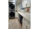 Well-organized laundry room with stacked washer and dryer, quartz countertop, ample cabinet space and modern fixtures at 1343 Peachtree Battle Nw Ave, Atlanta, GA 30327