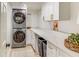 Bright laundry room featuring front-load washer/dryer and sleek white cabinets with ample counter space at 1343 Peachtree Battle Nw Ave, Atlanta, GA 30327