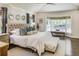 Bright main bedroom features a tufted headboard, sitting area, hardwood floors, and natural light from a large window at 1343 Peachtree Battle Nw Ave, Atlanta, GA 30327