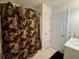 A full bathroom with a floral shower curtain and white door offers a private and functional space at 19 Windcrest Dr, Covington, GA 30016