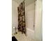 Bathroom featuring a tub/shower combo with floral curtain, alongside a wall-mounted paper holder and clean white tile at 19 Windcrest Dr, Covington, GA 30016