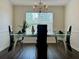 A well-lit dining room with a modern glass table set for four, creating an inviting space for meals at 19 Windcrest Dr, Covington, GA 30016