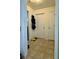 Functional hallway with neutral tones and tile flooring, featuring multiple storage doors at 19 Windcrest Dr, Covington, GA 30016