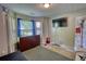A cozy bedroom features a closet with a TV and dresser, with natural light from double windows at 2000 Redwood Trce, Ellenwood, GA 30294