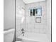 Close-up of a shower and toilet area in a renovated bathroom featuring white marble tile at 2814 Lloyd Rd, Decatur, GA 30034