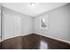 Neutral bedroom featuring dark wood floors, a closet, and natural light from the window at 2814 Lloyd Rd, Decatur, GA 30034