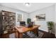 Home office with a wooden desk, bookshelf, and a comfortable leather chair at 2814 Lloyd Rd, Decatur, GA 30034
