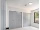 Sunlit bedroom showcasing wall to wall carpets and two closets, illuminated by a window with a wooded backyard view at 5346 Kelleys Mill Cir, Stone Mountain, GA 30088