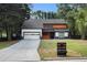 Modern two-story home with a dark roof, light wood accents, and a long driveway at 5346 Kelleys Mill Cir, Stone Mountain, GA 30088