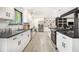 Kitchen with white cabinets, stainless steel appliances and black countertops. Features view into the living room at 5346 Kelleys Mill Cir, Stone Mountain, GA 30088