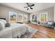 This bedroom features a ceiling fan, hardwood floors, and a picturesque view from the three windows at 939 Whistler Ln, Canton, GA 30114