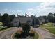 Aerial view featuring the welcome center, flags, and lush trees and manicured landscaping at 940 River Valley Dr, Dacula, GA 30019