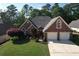 Charming brick home with a two-car garage, mature trees, and a well-manicured lawn at 940 River Valley Dr, Dacula, GA 30019