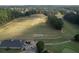 Aerial view showcasing the driving range, golf course, club house, golf carts, and surrounding trees at 940 River Valley Dr, Dacula, GA 30019