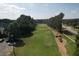 An elevated view of golf course with green grass, trees, road, golf carts, and cloudy skies at 940 River Valley Dr, Dacula, GA 30019