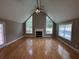 Bright living room boasts hardwood floors, a vaulted ceiling, three windows and a fireplace at 940 River Valley Dr, Dacula, GA 30019