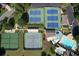 An aerial shot shows tennis courts, playground, and a pool with a water slide amidst lush greenery and parking at 940 River Valley Dr, Dacula, GA 30019