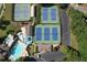 Aerial view of six well maintained tennis courts with a pool, playground, parking lot and surrounding trees at 940 River Valley Dr, Dacula, GA 30019